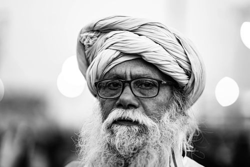 Free Elderly man in a turban, glasses, and beard depicted in a striking black and white portrait. Stock Photo