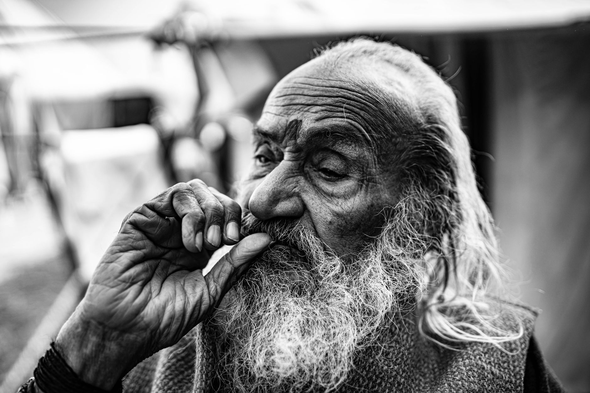 A close-up portrait capturing the emotions of an elderly man in candid black and white photography.