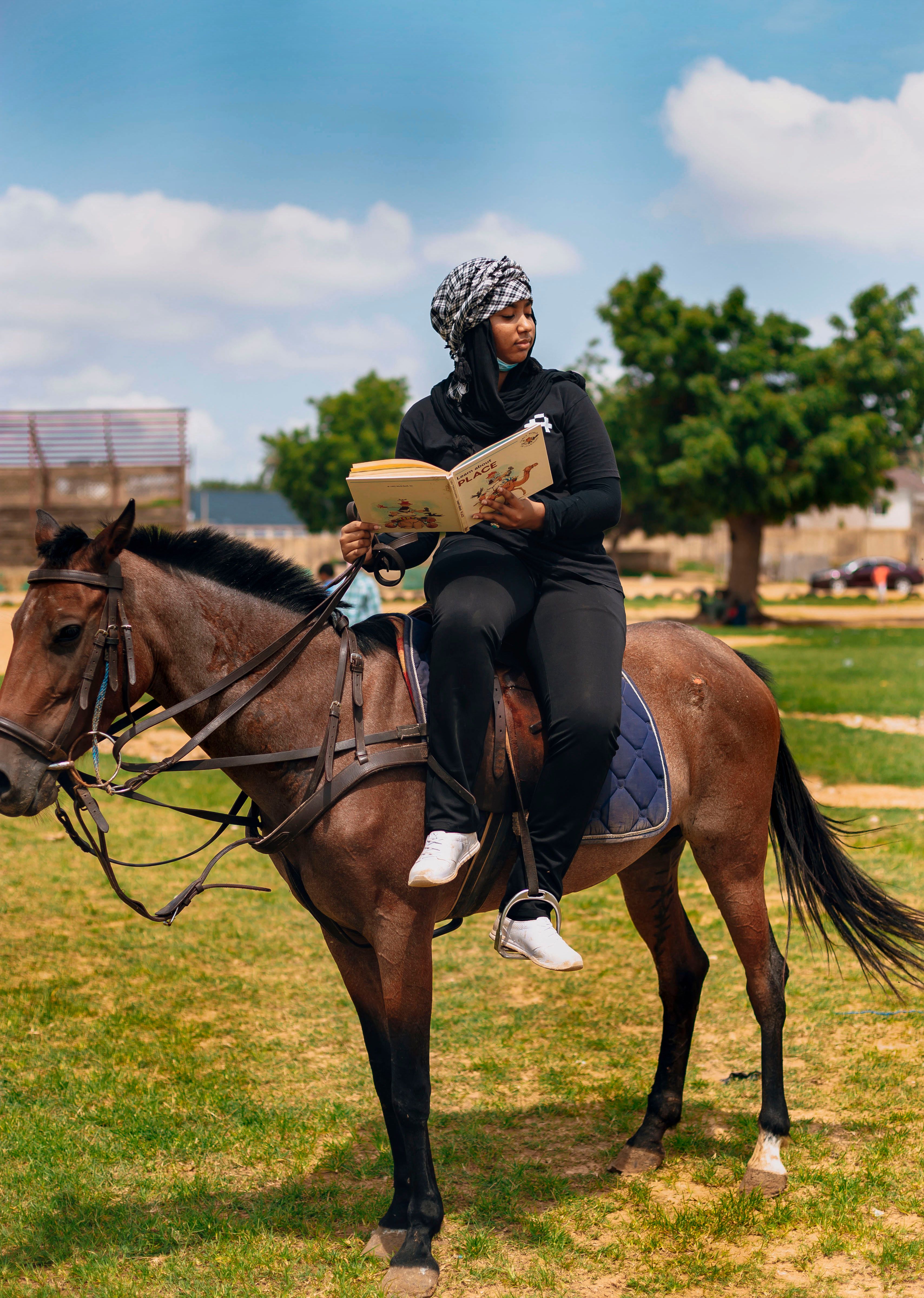 woman-reading-while-horseback-riding-outdoors-free-stock-photo
