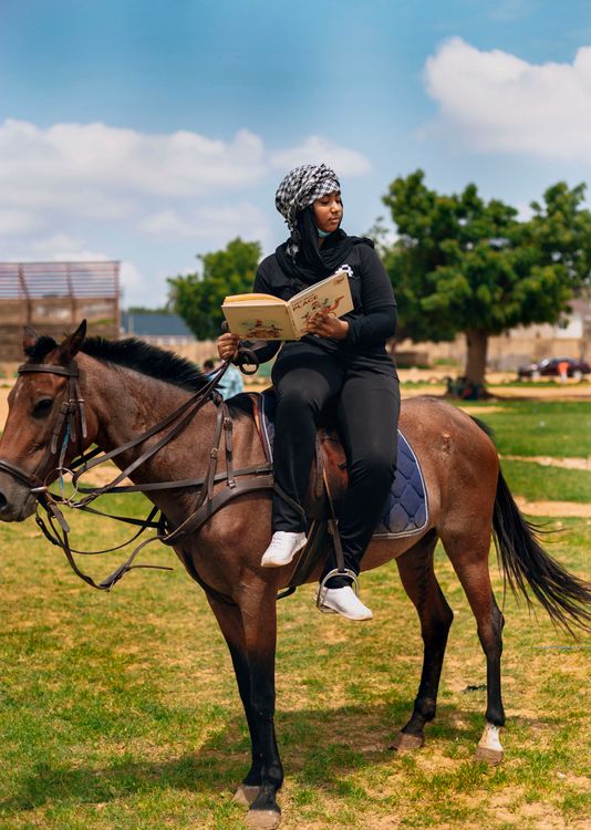 Woman Reading While Horseback Riding Outdoors Free Stock Photo woman-reading-while-horseback-riding-outdoors-free-stock-photo