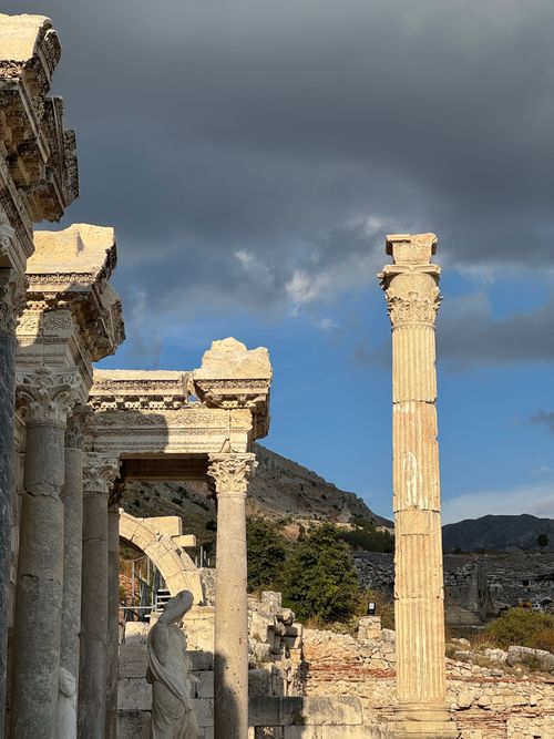 Free Stunning view of ancient Roman columns amidst dramatic clouds. Stock Photo