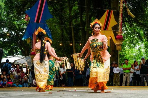 Free Colorful traditional Balinese dance performance with dancers in ornate costumes entertaining an outdoor crowd. Stock Photo