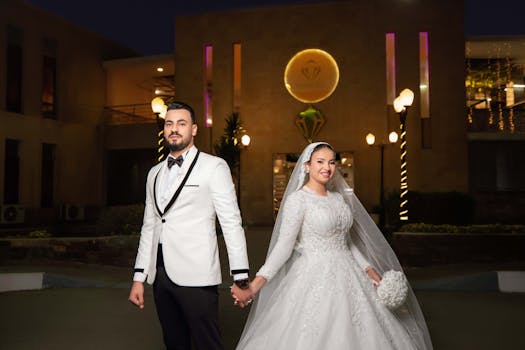 A classy evening wedding portrait featuring a newlywed couple in elegant attire celebrating their special day.