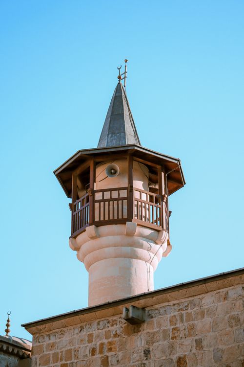 Free A beautiful minaret with intricate design stands tall against a clear blue sky, showcasing traditional architecture. Stock Photo