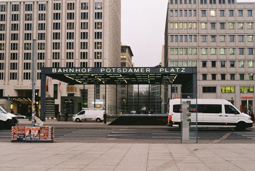 Urban scene of Bahnhof Potsdamer Platz in Berlin with visible modern architecture and vehicles.