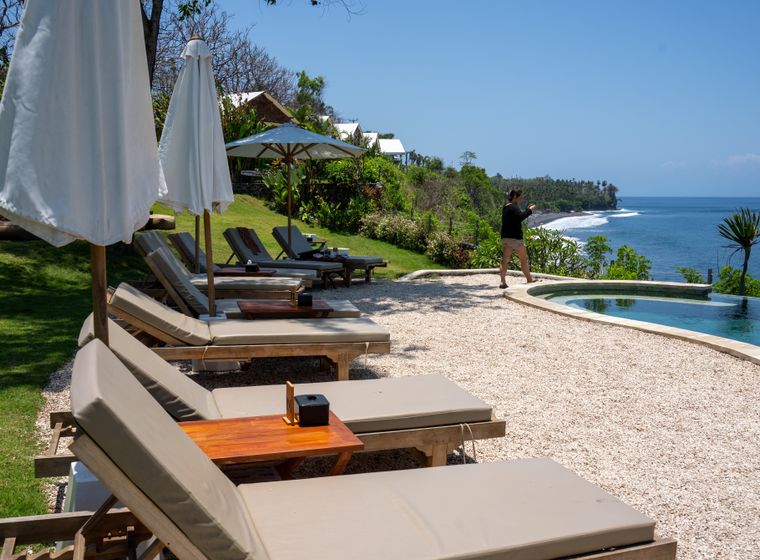Sun loungers lined along a quiet resort pool deck