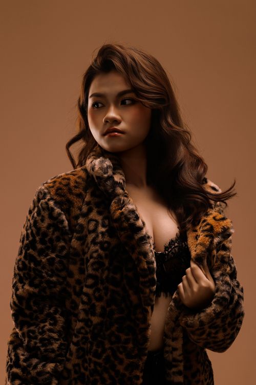 Free Elegant portrait of a woman wearing a leopard print coat, exuding confidence and style. Stock Photo