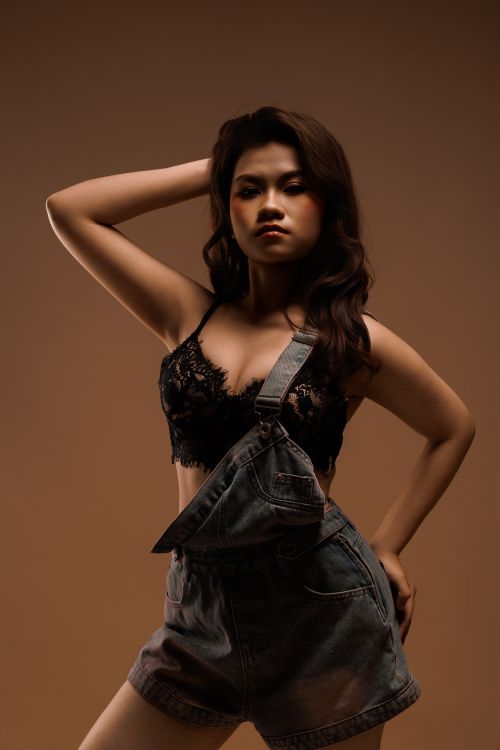 Free Striking portrait of a young woman in a fashionable outfit posing indoors. Stock Photo