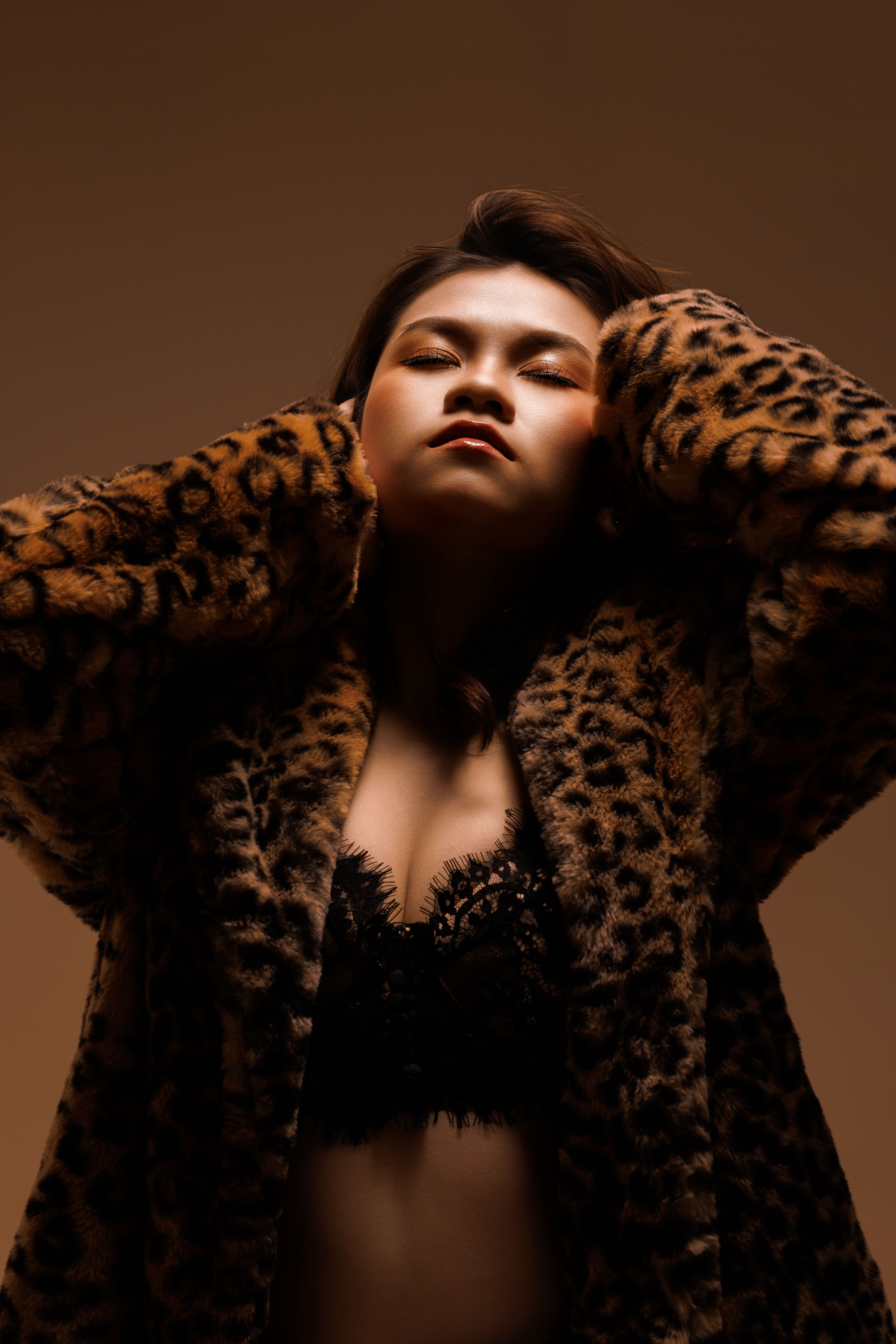 Portrait of an Asian woman in a leopard print coat, exuding confidence and style.