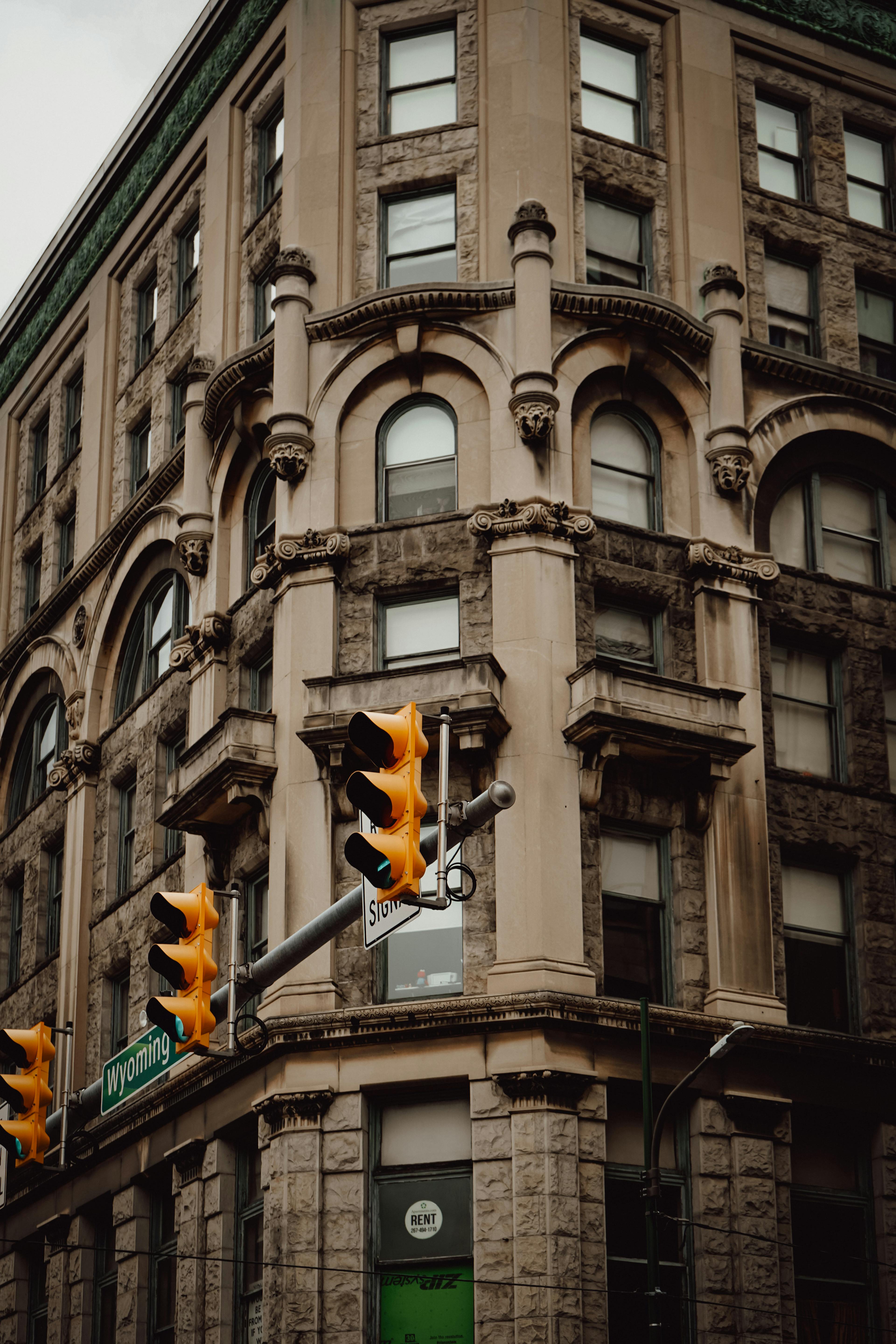 Free A classic stone building corner with vintage traffic lights in an urban setting, showcasing architectural details. Stock Photo