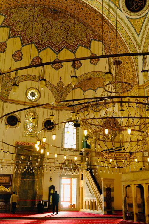 Free Stunning view of a mosque's interior featuring intricate ceiling designs and grand chandeliers. Stock Photo