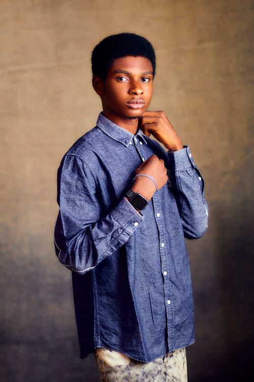 Free Stylish young man posing confidently in a denim shirt with watch. Stock Photo