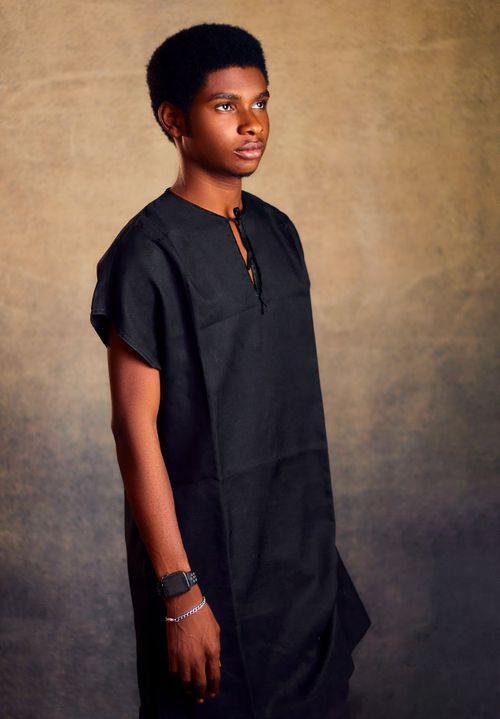 Free Elegant portrait of a young man wearing traditional black attire against a neutral background. Stock Photo