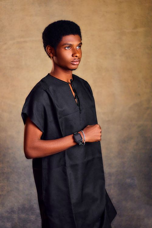 Free Elegant young man in traditional black attire, striking a confident pose. Stock Photo