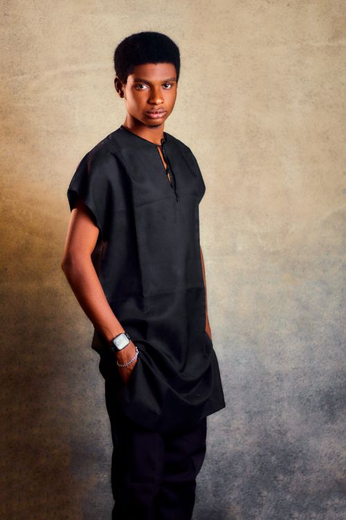 Free Portrait of a young man wearing traditional black attire against a textured background. Stock Photo