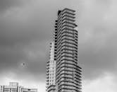 一座现代化的摩天大楼矗立在阴沉的天空下，展现了当代建筑的风格