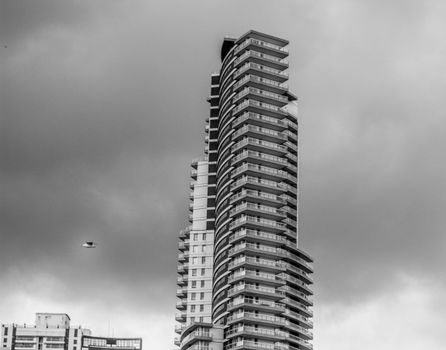 一座现代化的摩天大楼矗立在阴沉的天空下，展现了当代建筑的风格
