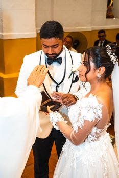 Bride and groom exchanging vows in a formal wedding ceremony indoors.