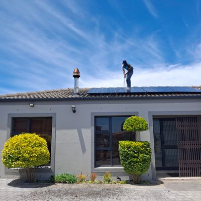 Worker installing solar panels on a residential roof