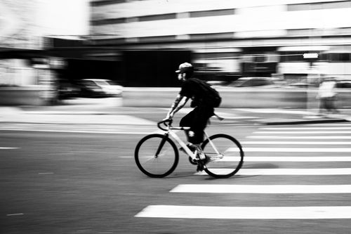 Free Black and white capture of a cyclist in motion, speeding through São Paulo's streets, highlighting urban life. Stock Photo