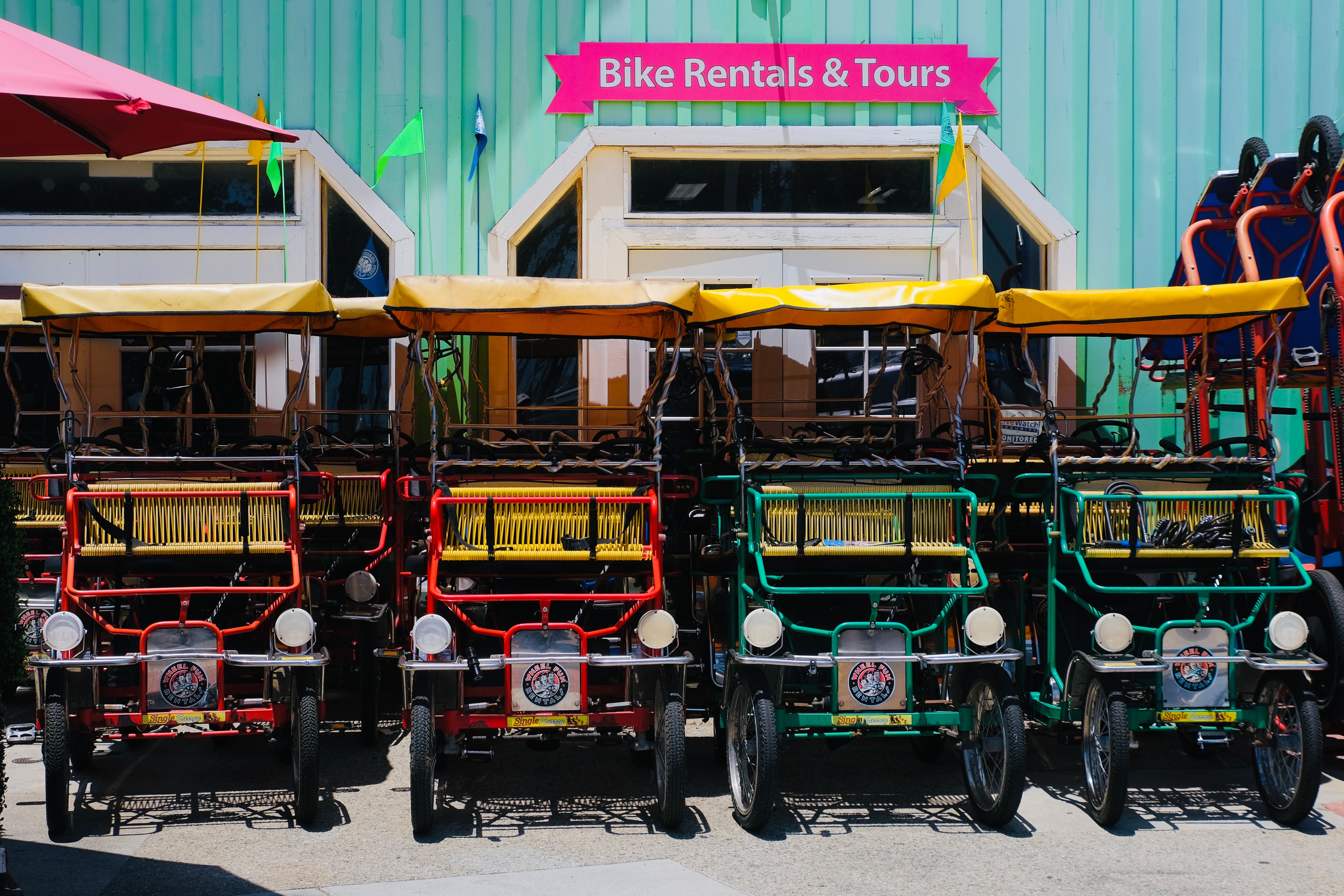 Bright rental bikes ready for tours outside a rental shop.