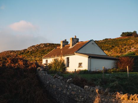 Sunny afternoon view of a traditional Irish cottage in Dublin's scenic countryside.