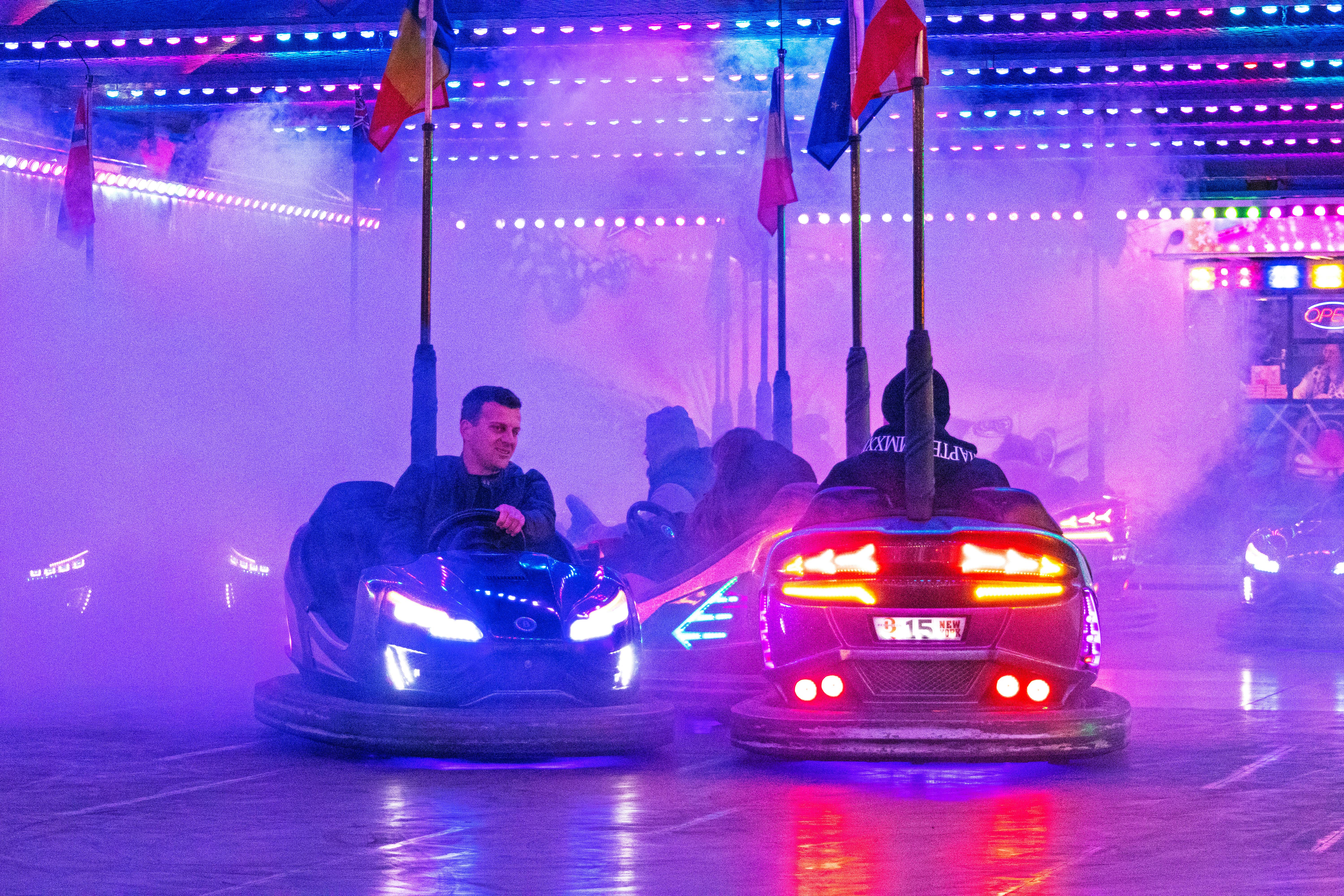 Vibrant bumper cars ride with colorful lights and smoke at a Budapest carnival. Nighttime fun and excitement. - Photo by Ny Zoltán on Pexels