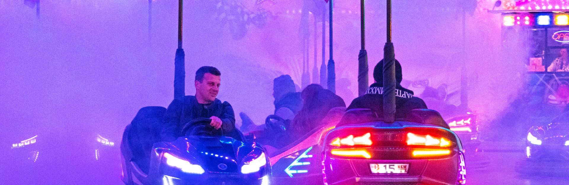 Vibrant bumper cars ride with colorful lights and smoke at a Budapest carnival. Nighttime fun and ex