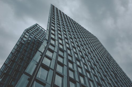 Photographie à Faible Angle D'un Immeuble De Grande Hauteur De Mur Rideau Sous Un Ciel Nuageux