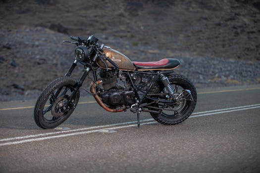 Detailed view of a vintage cafe racer motorcycle parked on a deserted road.