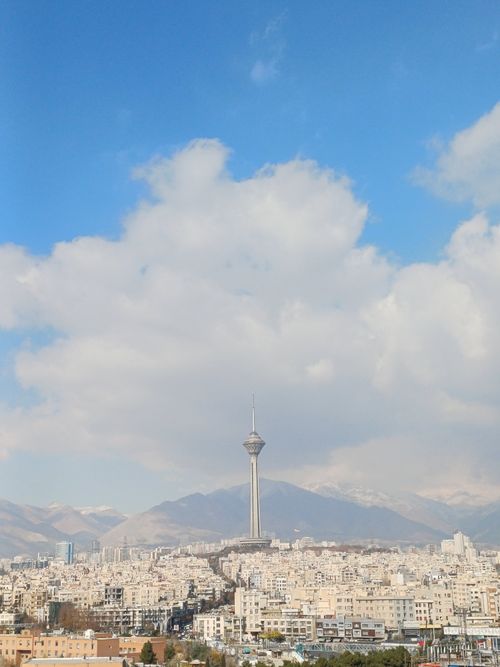 Free Scenic view of Milad Tower amidst Tehran's sprawling cityscape and mountain backdrop. Stock Photo