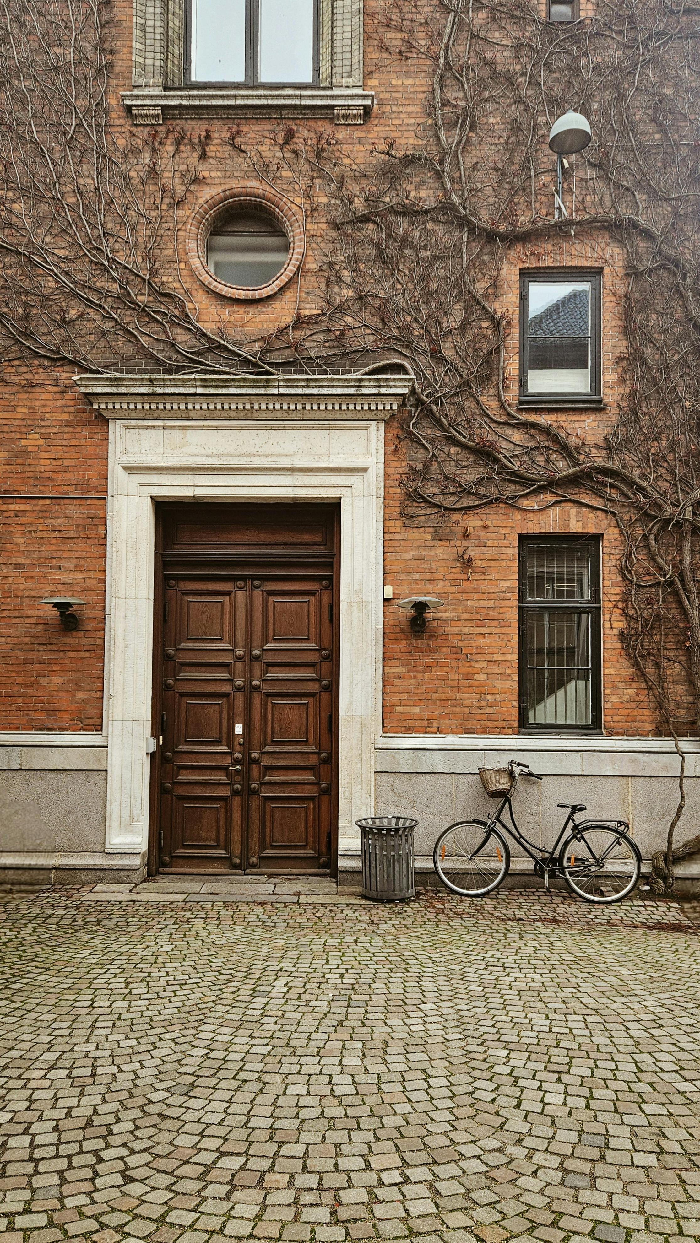Charming brick building with ivy and a bicycle in Copenhagen, Denmark.