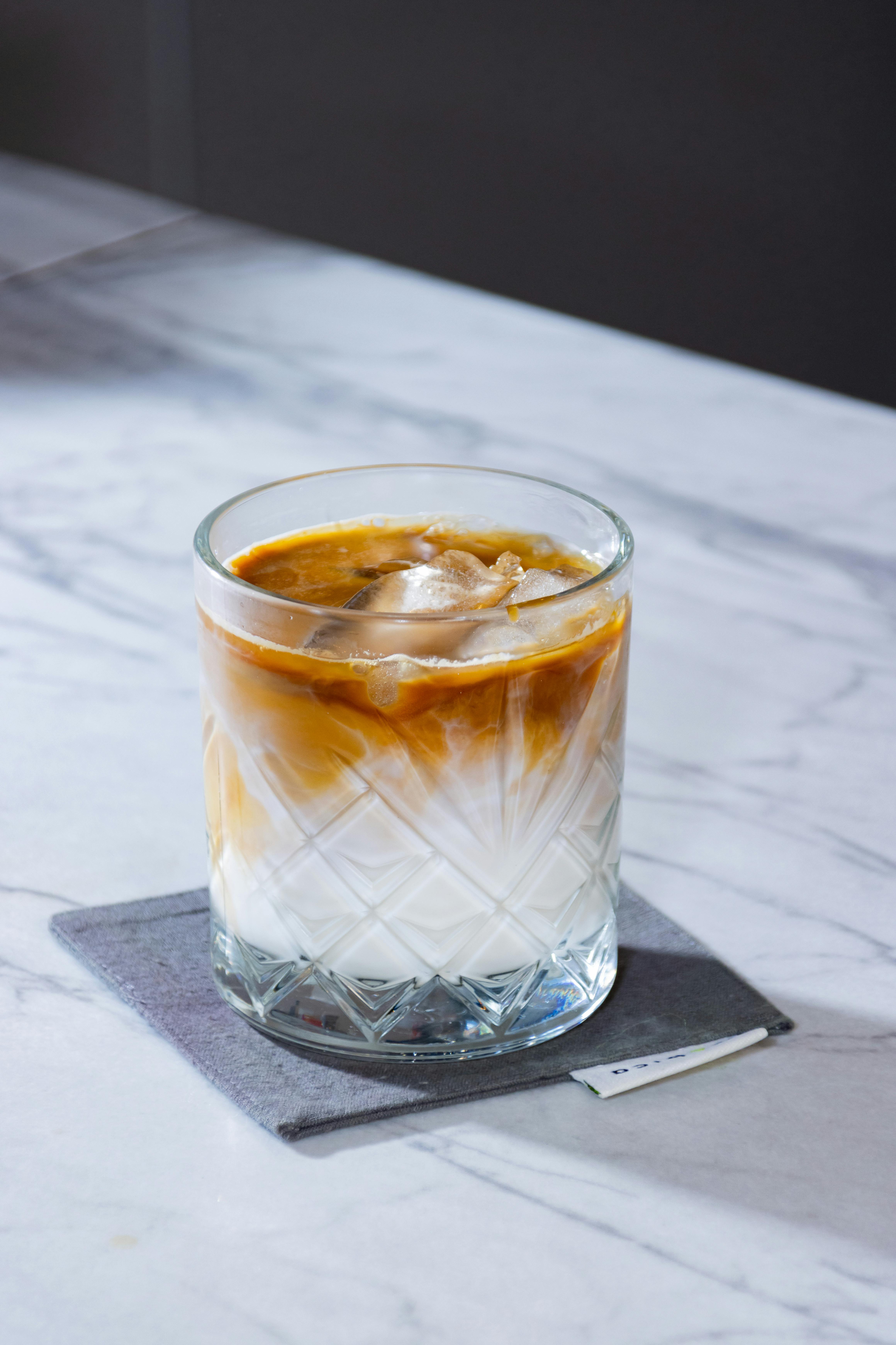 Iced latte in textured glass on a bright table