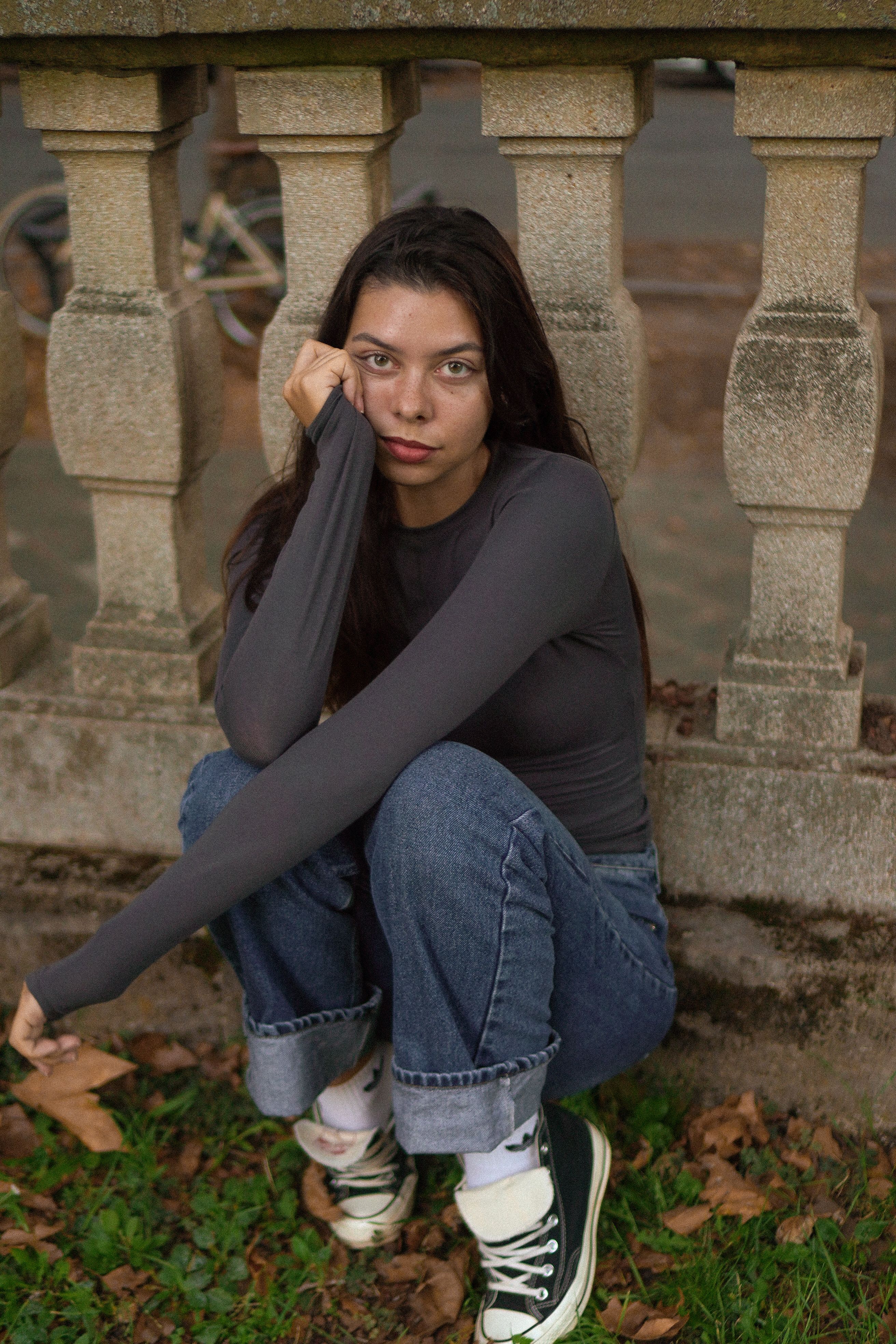 Young Woman Sitting Outdoors in Casual Attire · Free Stock Photo