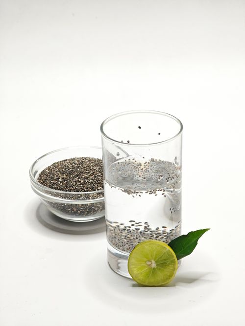 Free Glass of chia seed water with lime slice on white background, showcasing health and freshness. Stock Photo