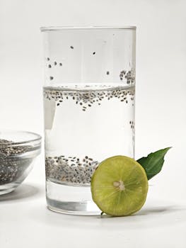 Glass of chia-infused water with lime slice, perfect for hydration and health.