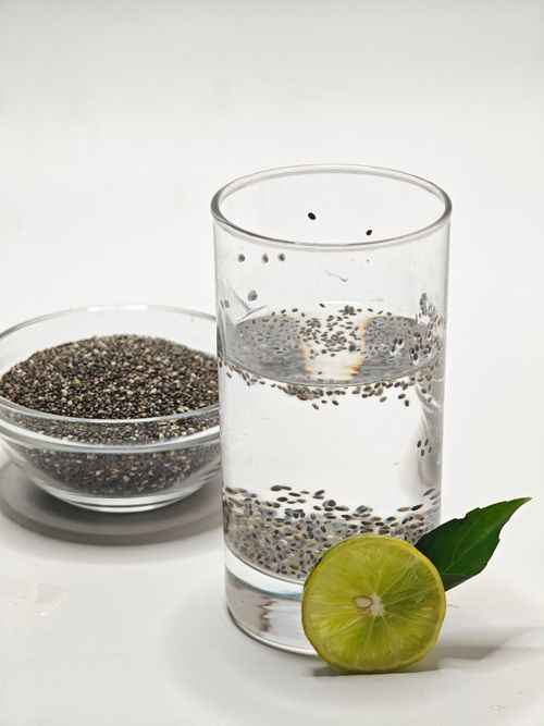 Free Glass of chia seed water with a lime slice and bowl of seeds on white surface. Stock Photo