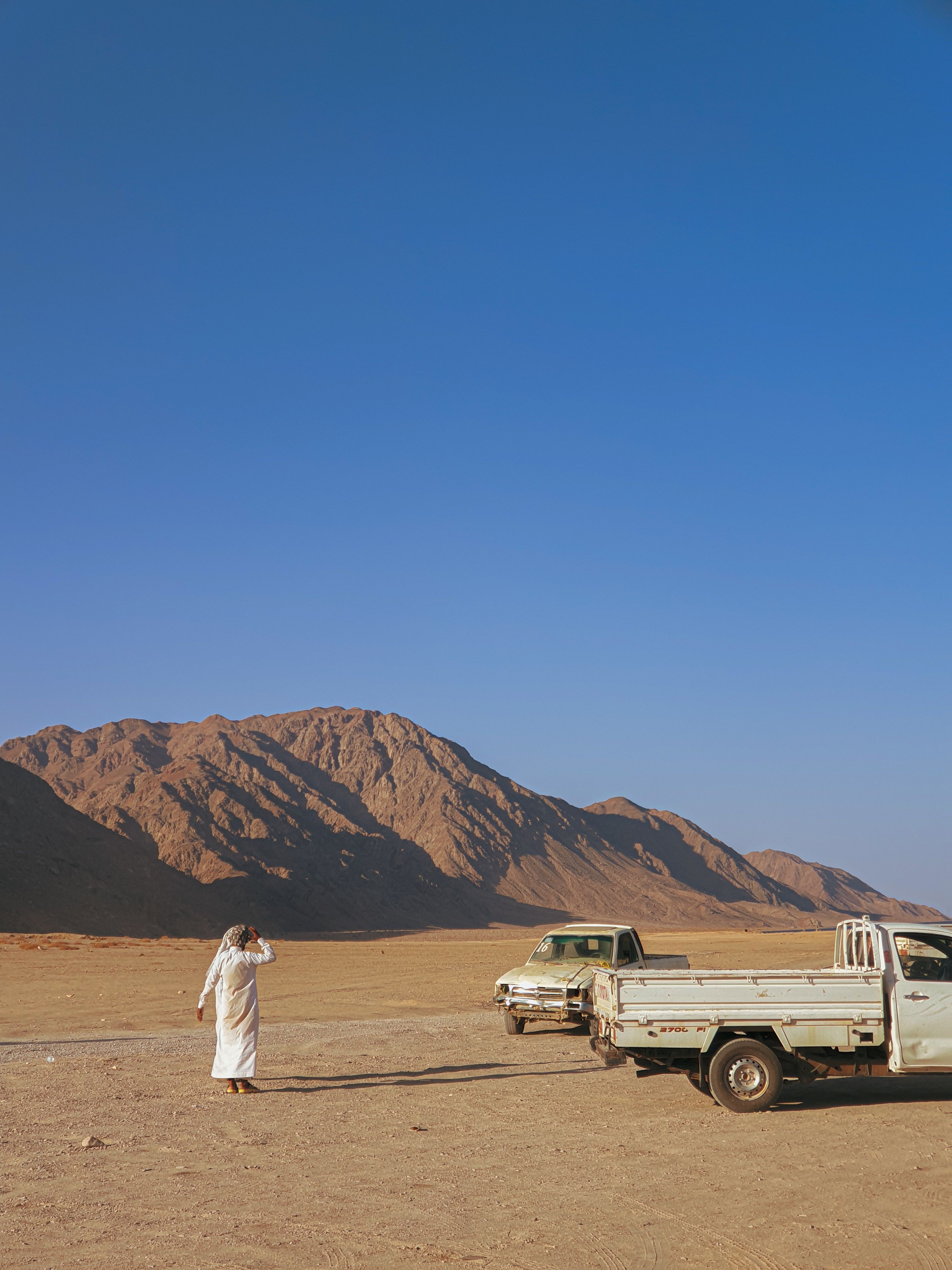 Man in Desert Landscape with Trucks in Dahab · Free Stock Photo
