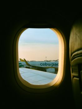 A serene view from an airplane window showcasing an aircraft wing during sunset.
