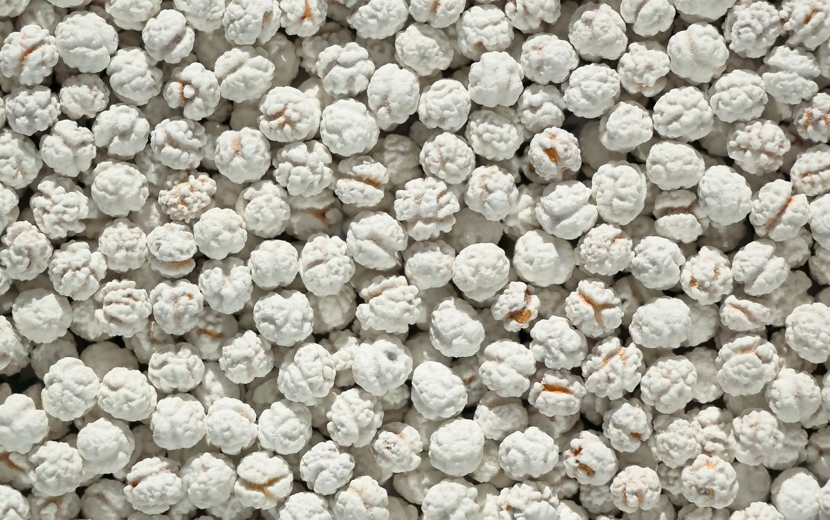 Top view of white sugar-coated fennel seeds creating a textured background.