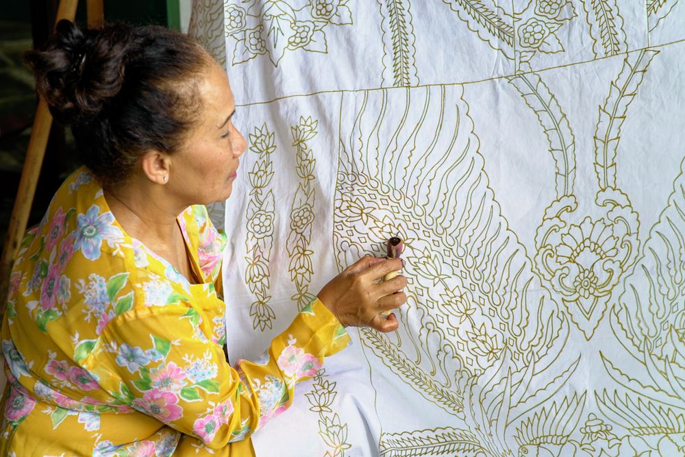Pengrajin membuat motif batik di atas kain