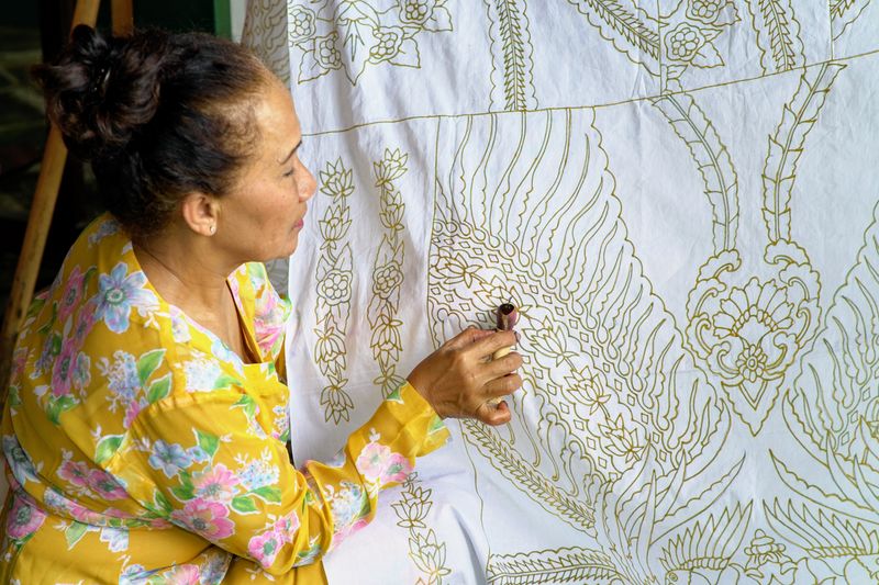 Pengrajin membatik dengan canting Pengrajin membatik dengan canting