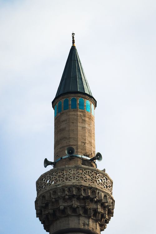 Free A detailed capture of a mosque's minaret showcasing Islamic architecture under a clear sky. Stock Photo