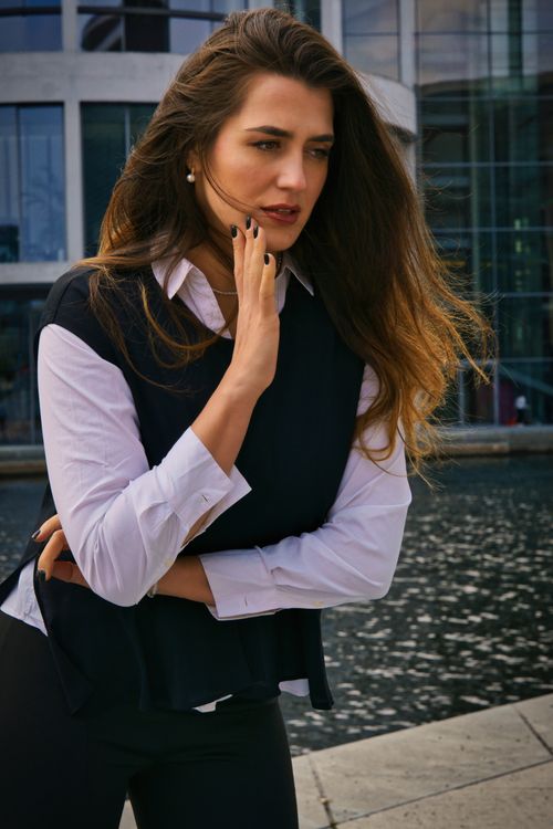 Free Elegant woman in professional attire posing by a waterfront in Berlin, Germany. Stock Photo