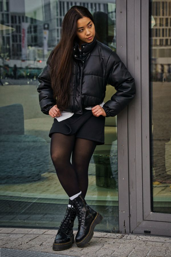 Woman in black denim mini skirt with puffer jacket