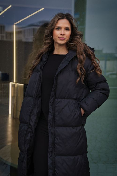 Free Stylish woman in black winter coat posing confidently outdoors in Berlin, Germany. Stock Photo