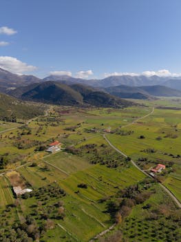 Stunning aerial shot of Limni valley in Greece showcasing lush greenery and distant mountains.