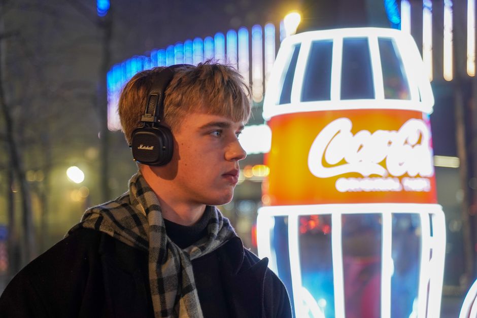 Man enjoying music in front of neon lights in Kyiv, Ukraine at night.