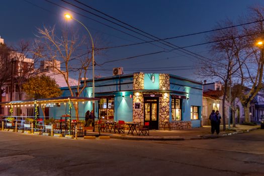 Charming evening view of a lit cafe in Mar del Plata, Argentina, exuding warmth and nightlife.