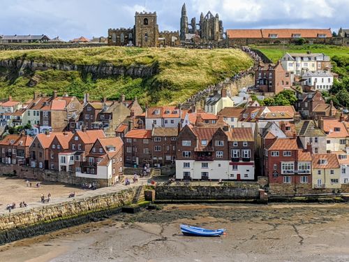 Free Picturesque view of Whitby Abbey and the town's historic houses under a bright sky. Stock Photo